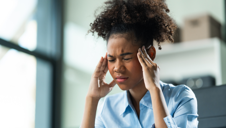 Osoba trzymająca głowę z bólu – ilustracja tematu adaptogeny a migrena i naturalnych sposobów łagodzenia bólów głowy.